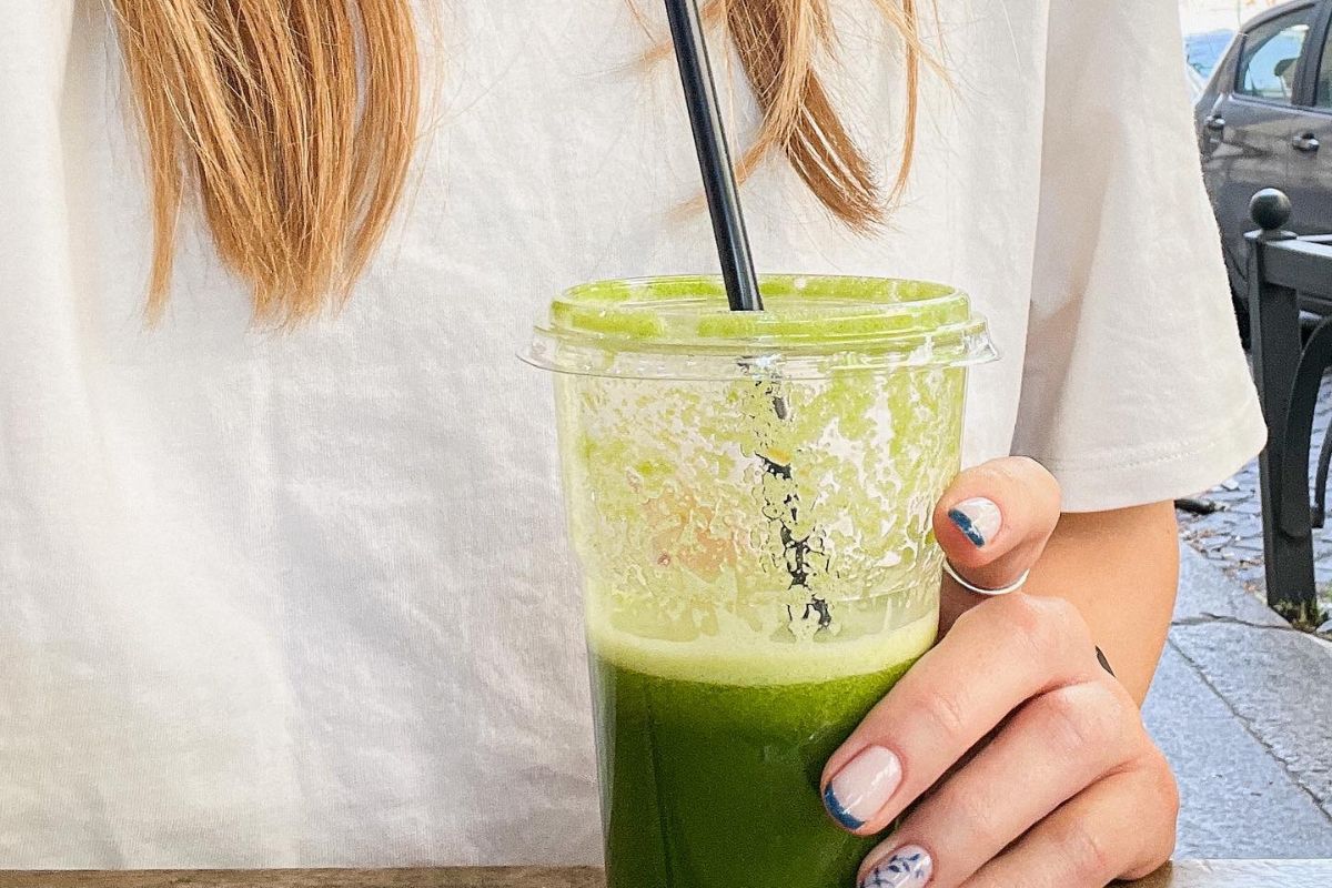 Mergina gerianti žalią kokteilį